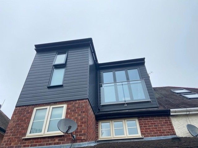 'L' Shaped flat roof dormer with Anthracite Upvc cladding, Aluminium bi-folding doors and glass balustrade.: Swipe To View More Images