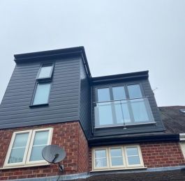 'L' Shaped flat roof dormer with Anthracite Upvc cladding, Aluminium bi-folding doors and glass balustrade.: Click Here To View Larger Image
